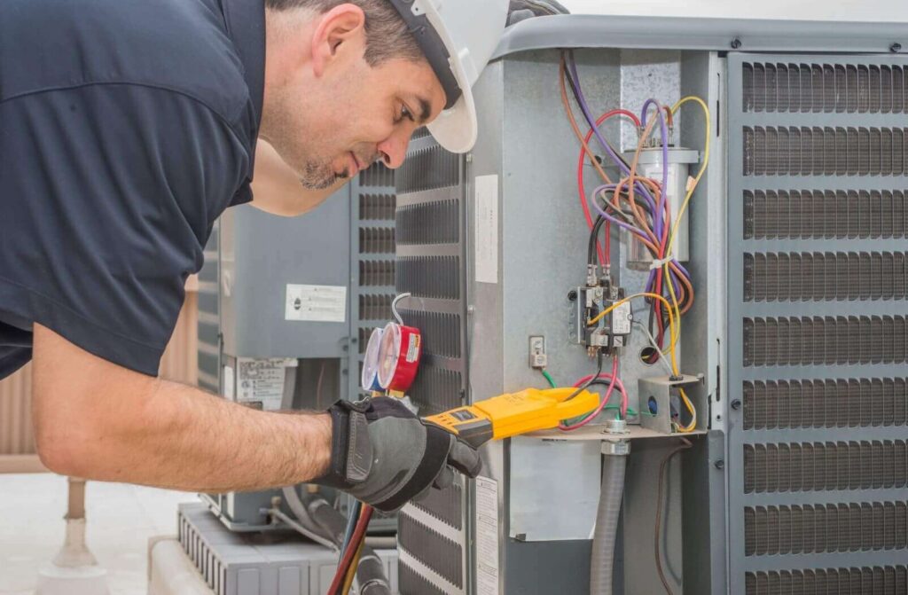 Bonney technician fixing electrical wires of an HVAC unit.